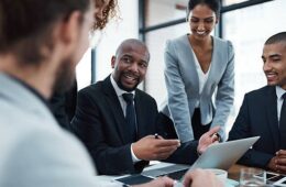 Shot of a group of businesspeople discussing something on a laptop