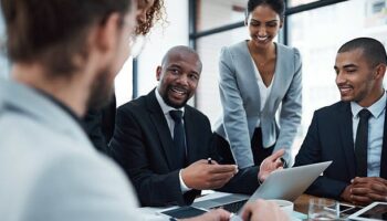 Shot of a group of businesspeople discussing something on a laptop