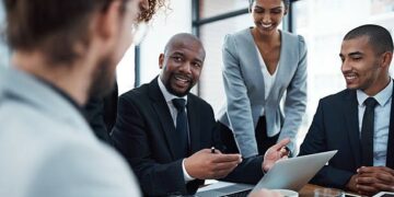 Shot of a group of businesspeople discussing something on a laptop